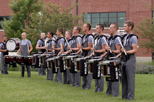The drum line warms up outside before the performance.